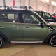 A dark green Mini Countryman SUV with black rims and roof bars